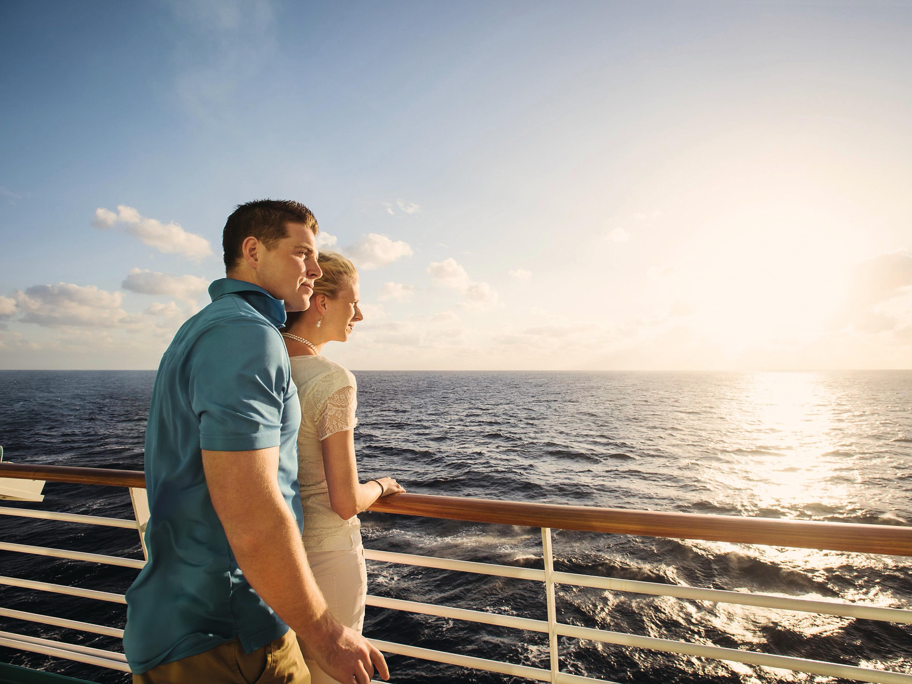 Ein Pärchen steht an der Reling und guckt auf das Wasser. 